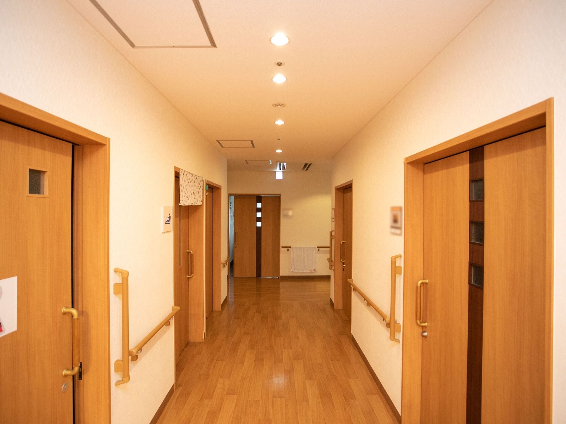 床は落ち着いた色合いのフローリングである。各部屋の扉はスライド式になっており、通路には手すりが備え付けられている。