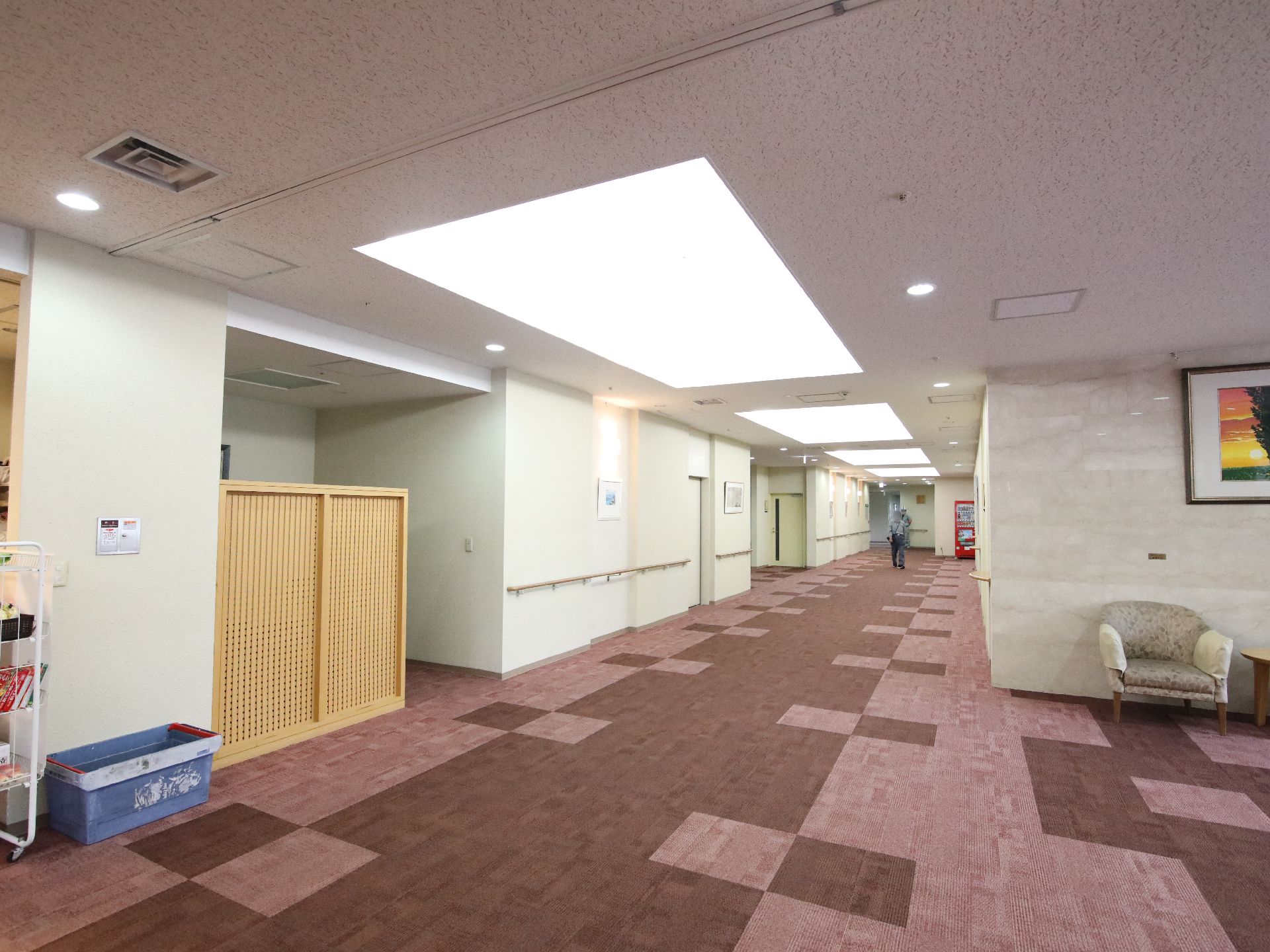 手すりと椅子が設置された、車椅子の入居者に配慮された廊下