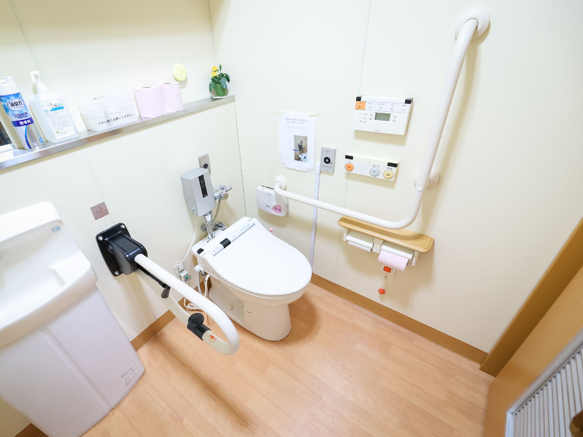 手すりが付いた白い壁際に並んだオストメイトパックと洋式便器