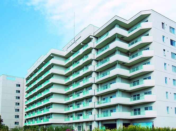 白を基調とした大きな建物はマンションのような雰囲気。各フロアにベランダがあり、周りには大きな建物はない。