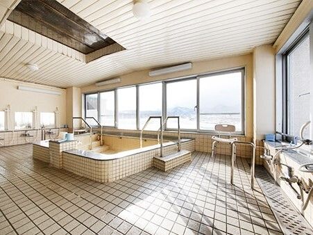 大きな窓が付いた広い浴室の両サイドにシャワースペースがあり、中央に大きな浴槽が付いている。