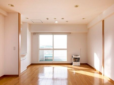 家具や家電は置かれていないシンプルなフローリングの部屋には洗面所が付き、大きな窓にはカーテンはない。