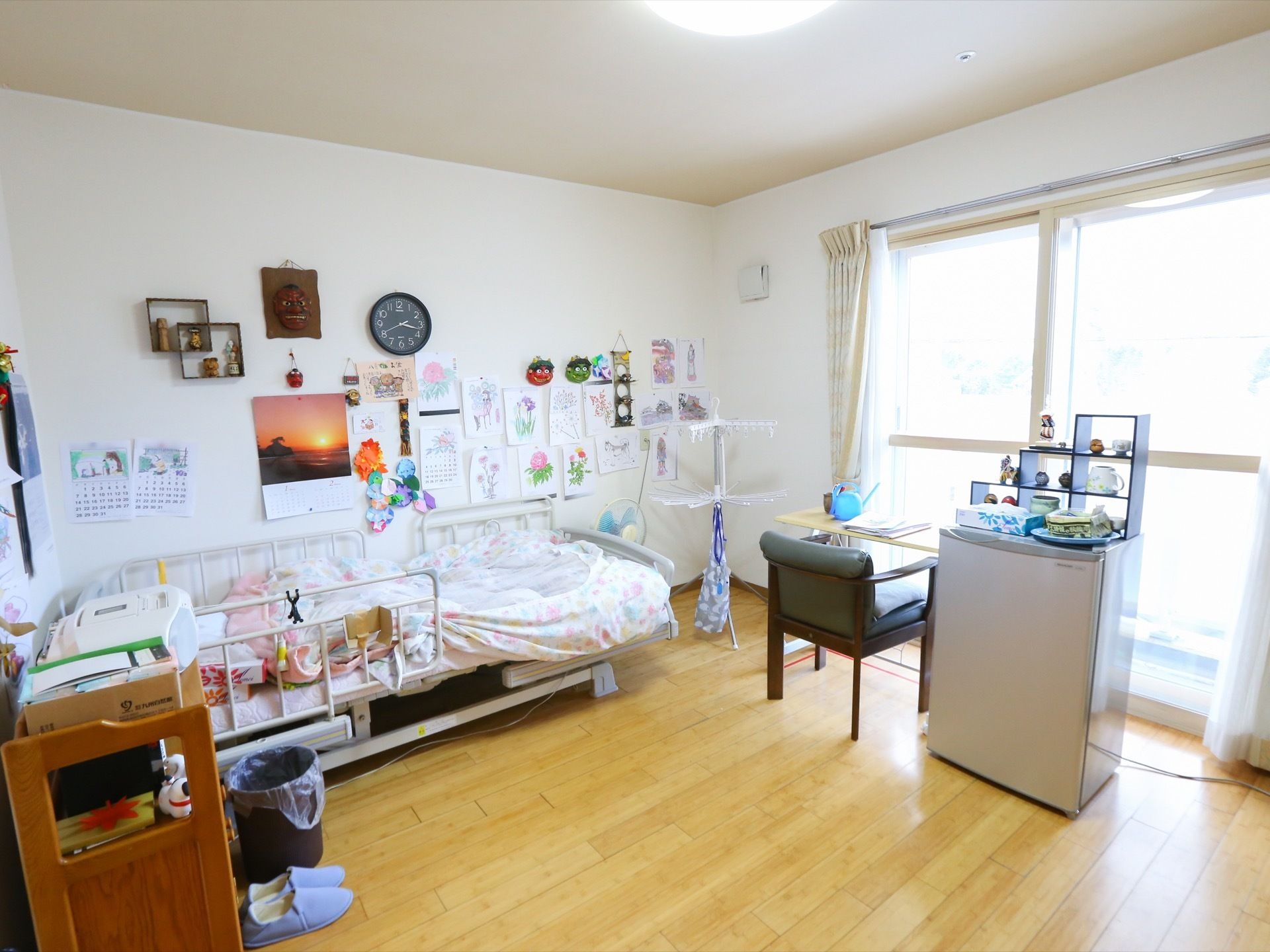 居室には窓があり、そのそばに椅子とテーブル、冷蔵庫が置かれている。ベッドには転落防止の柵が取り付けられている。