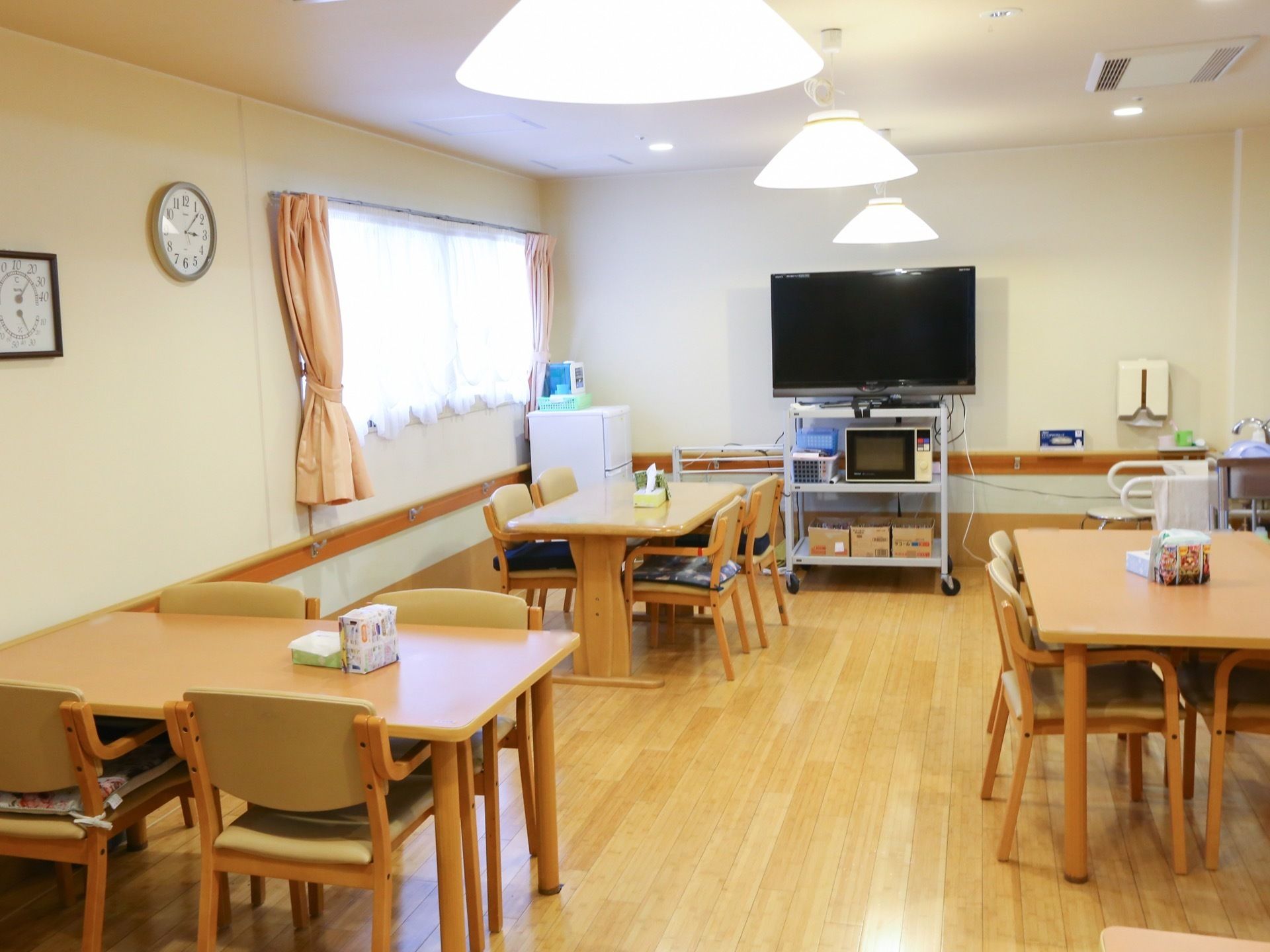 食堂には木製で４人掛けのテーブルが複数置かれている。天井からは暖かな光を放つ照明が３個吊り下げられている。
