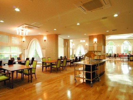 レストランのような雰囲気の食堂には少人数向けのダイニングテーブルが複数置かれ、窓の外には緑が広がっている。
