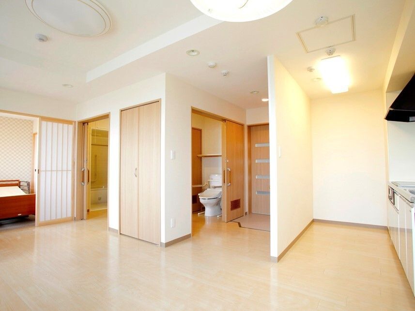 介護仕様の設備がついた家庭的な雰囲気の居室内。ドアや収納、トイレなどが写っている様子