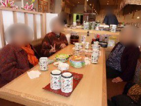 回転ずしやで写真に納まる高齢者の様子。奥のほうに回転ずしがあるのがわかる