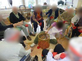 施設内の運動会で玉入れを楽しんでいる様子。輪になって玉を淹れている