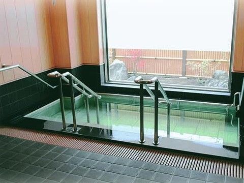 浴槽と腰壁に黒い御影石を使用した高級感のある浴室で、腰壁から上は無垢の板貼りになっており和の雰囲気となっている。