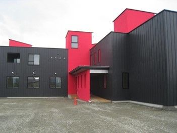赤と黒のツートンカラーのモダンなデザインの建物。遠くからでも生える色合い