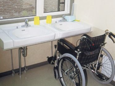 洗面所が二つ並び、一つには車いすが設置されている。足元スペースが空いているため、だれでも使い勝手がいい。