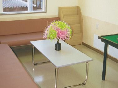 白いテーブルには花が添えられ、テーブルを囲むように暖色系の長椅子が二つ置かれている。