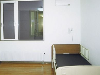 ベッドが置かれたフローリングの居室。窓が大きく、カーテンはまだつけられていない。