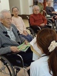 スタッフと一緒にレクリエーションを楽しんでいる車いすの入居者たち。