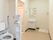 手前に洋式便器が据えられており、奧に洗面台が設置されている。トイレ付近の壁面にナースコールが取り付けてある。