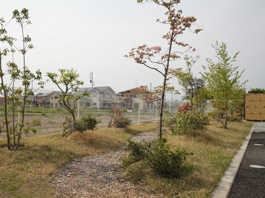 庭園には小道があり両サイドに木が植えられ、奥には和風庭園のようなものが見える。