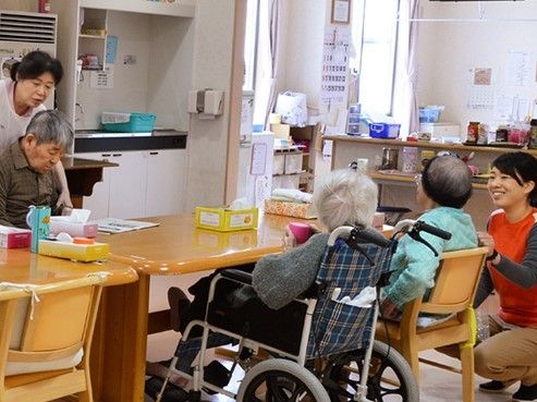 高齢者とスタッフが話している様子。キッチンのような広めのスペース