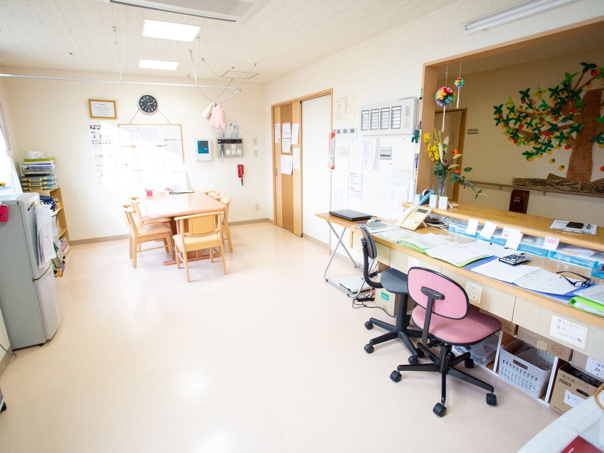 事務室は開放的で明るく、ご入居者様が立ち寄りやすいようにカウンターを設置している。カウンターにはお花や、工芸品などが飾られている。