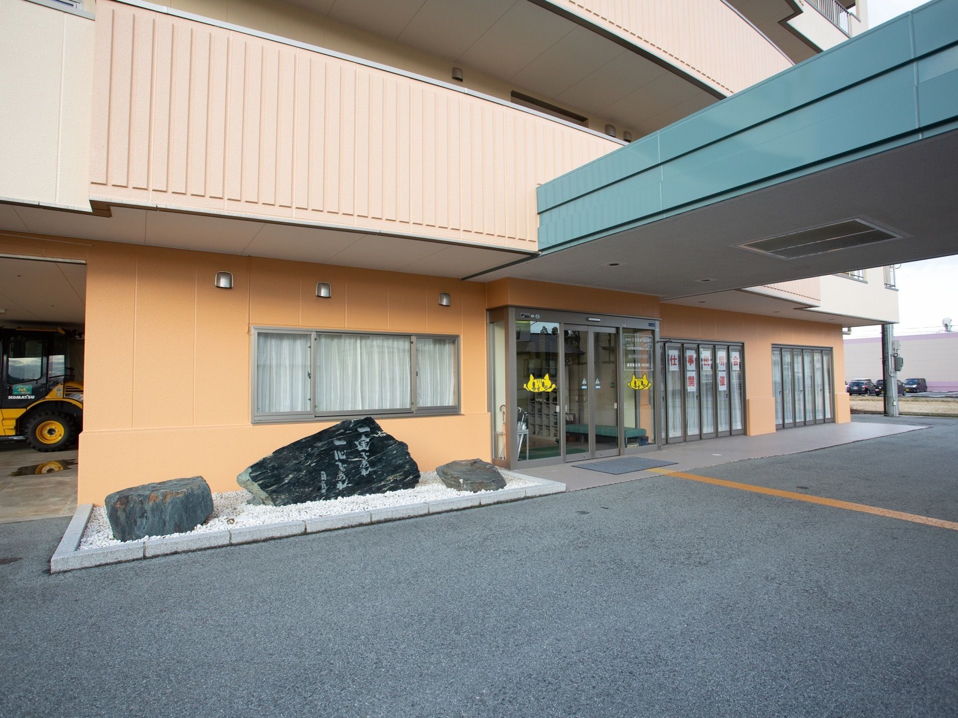 向かって左側に、施設のスローガンが彫られた岩を置いている。ドアは自動ドアであるため、車椅子をご利用の方にとっても出入りがしやすい。