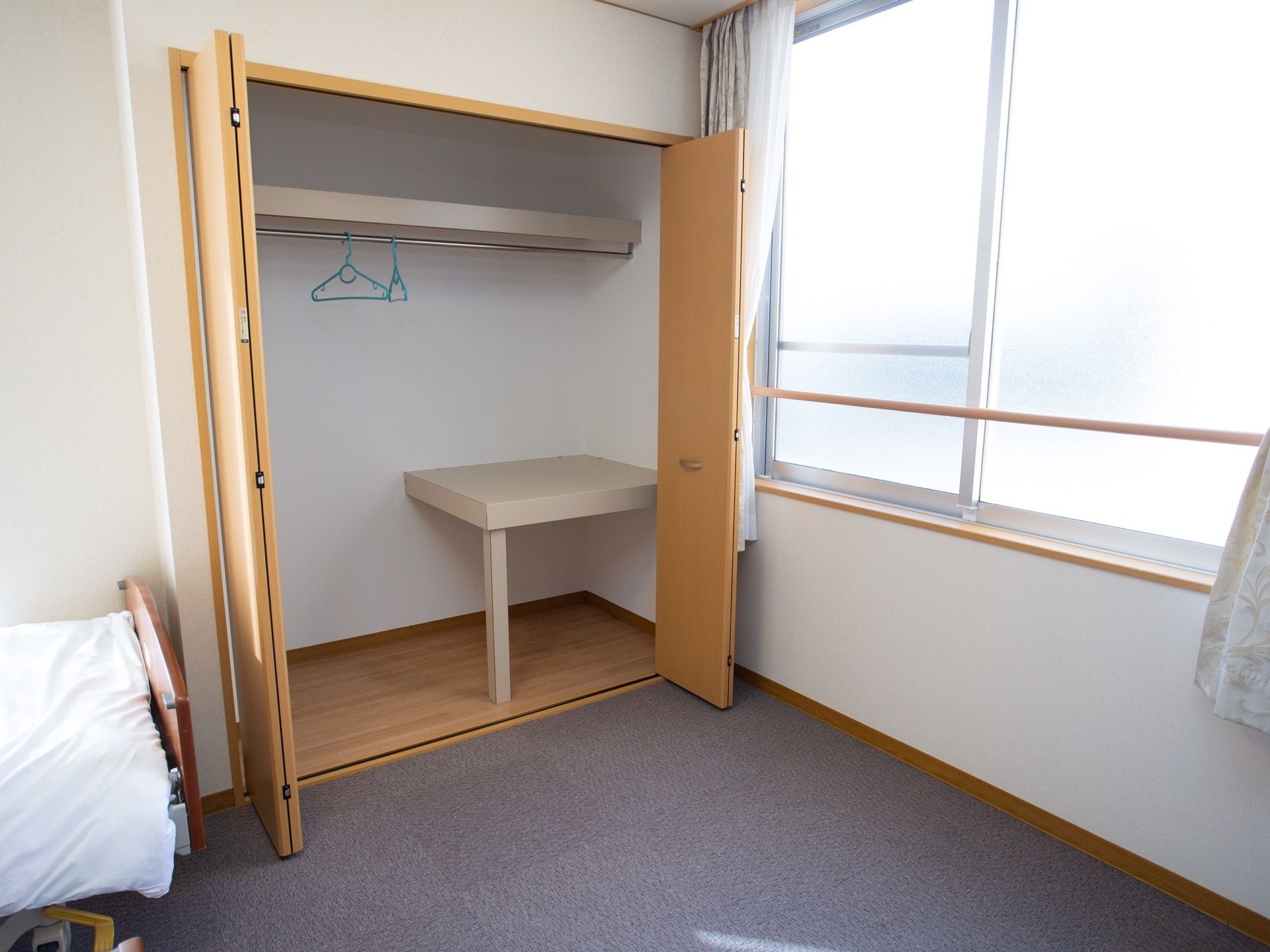 手前に手洗いがあり、向いの壁に椅子や収納が並んでいる。上下に分かれた食器棚と並んで、一番奥には台所がある。