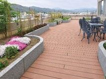 花壇や植込みがある屋上庭園の様子。ガーデン用のイスとテーブルが置いてあるスペース