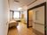 奥行きのある部屋に、ベッドや収納家具が置かれている。トイレの左右に緑色の手すりが施されており、扉は引き戸になっている。