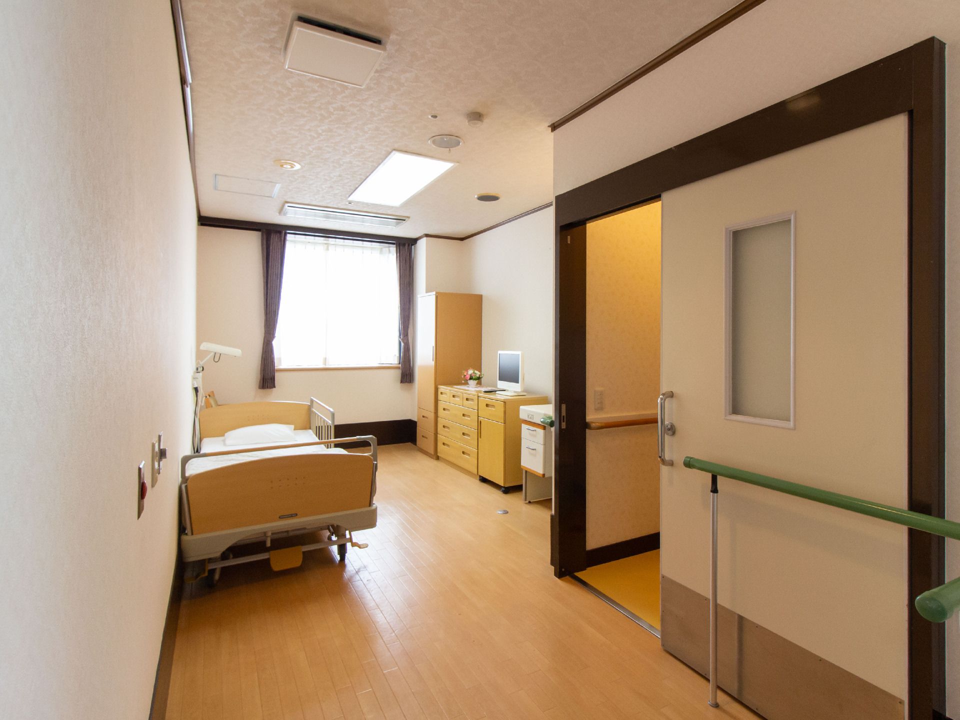 スライド式ドアや手すりや介護用ベッドなど介助設備を備えた個室