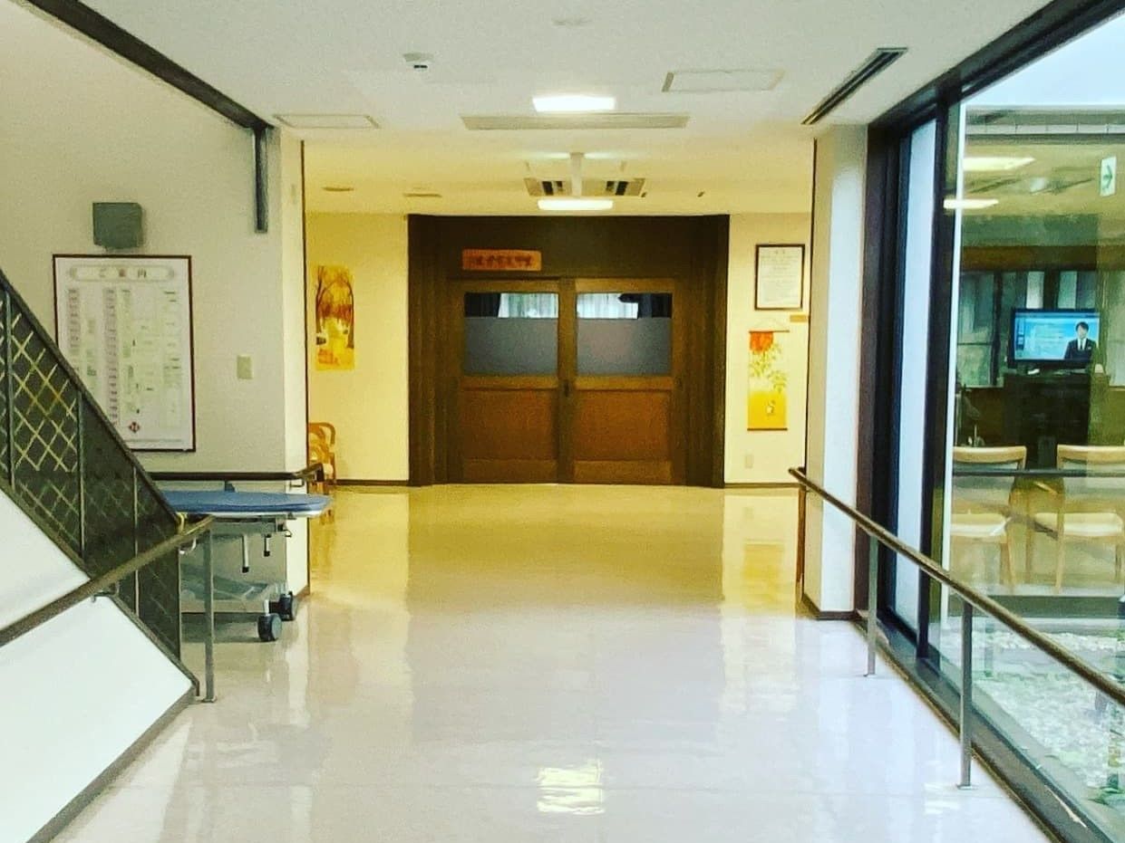 両サイドに手すりが付いた廊下は幅が広く、突き当りにはドアがある。