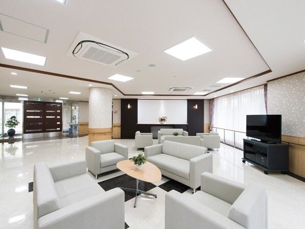 テレビが設置されたエントランス近くのホールにはグレーのソファの応接セットが置かれている。