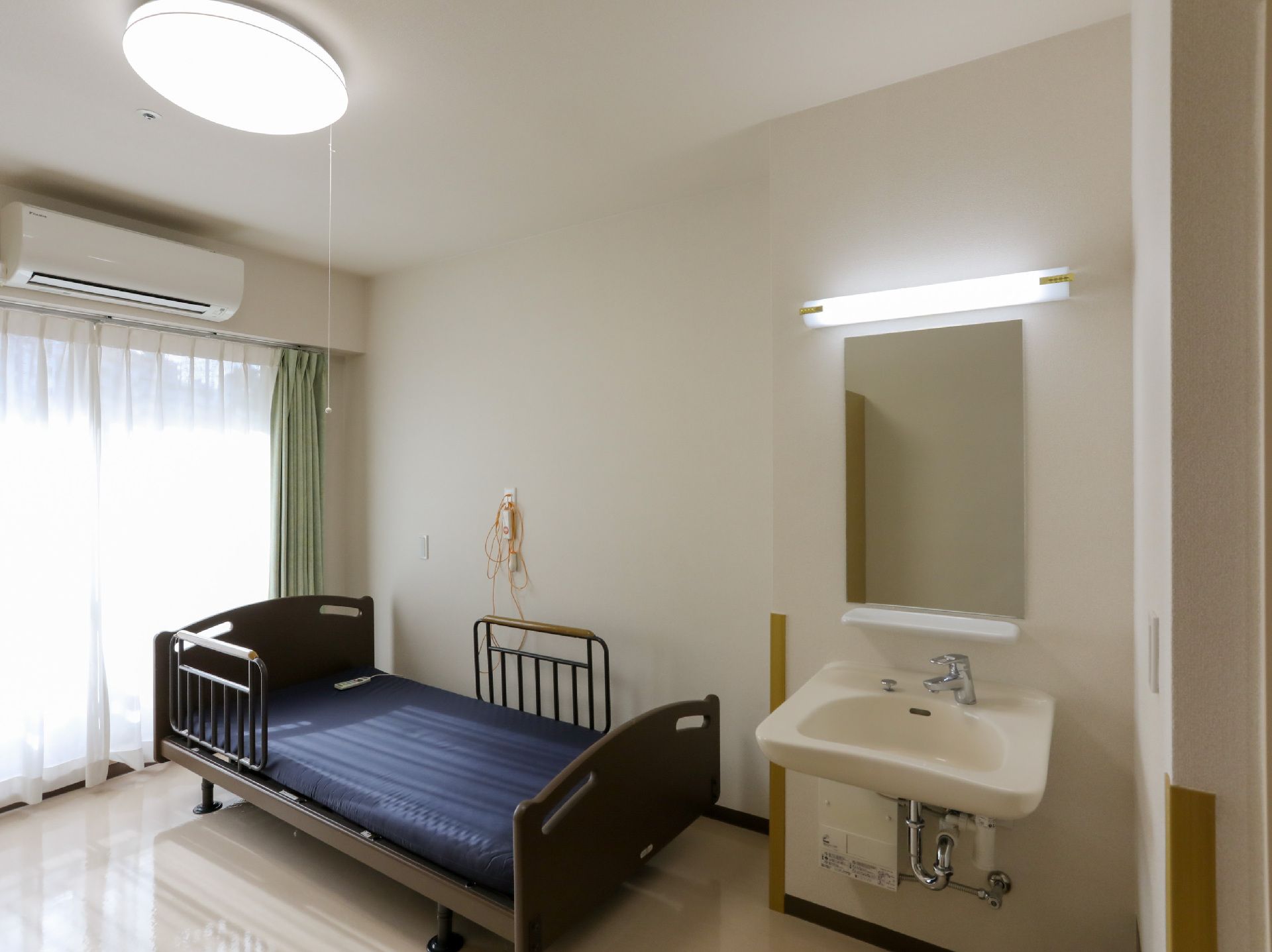 日差しが差し込み、介護ベッドや家具に日差しが当たっている居室