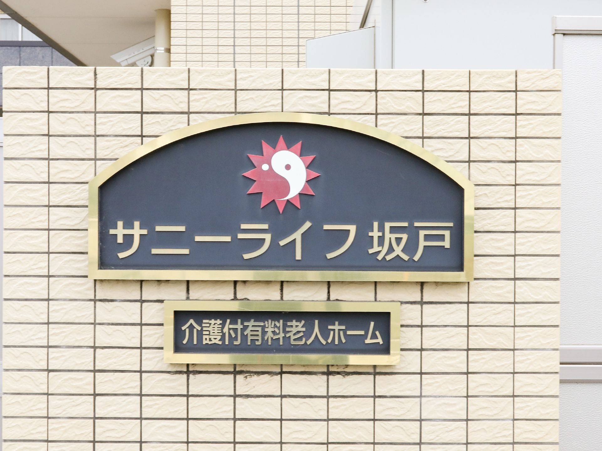 会社のロゴと施設名が書かれている看板