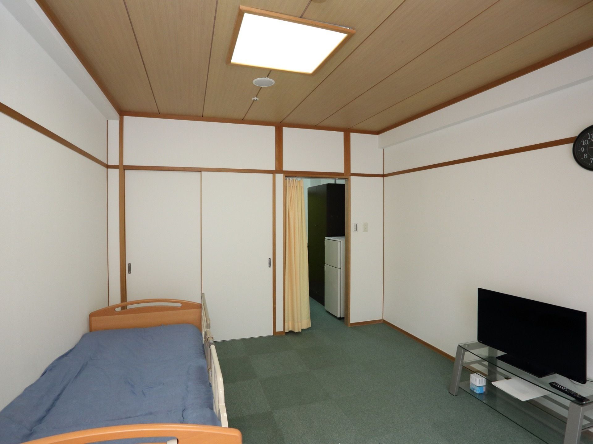 床は段差がなく、グリーンのカーペットが敷き詰められている。部屋へ入ってくる部分にはカーテンが取りつけられている。