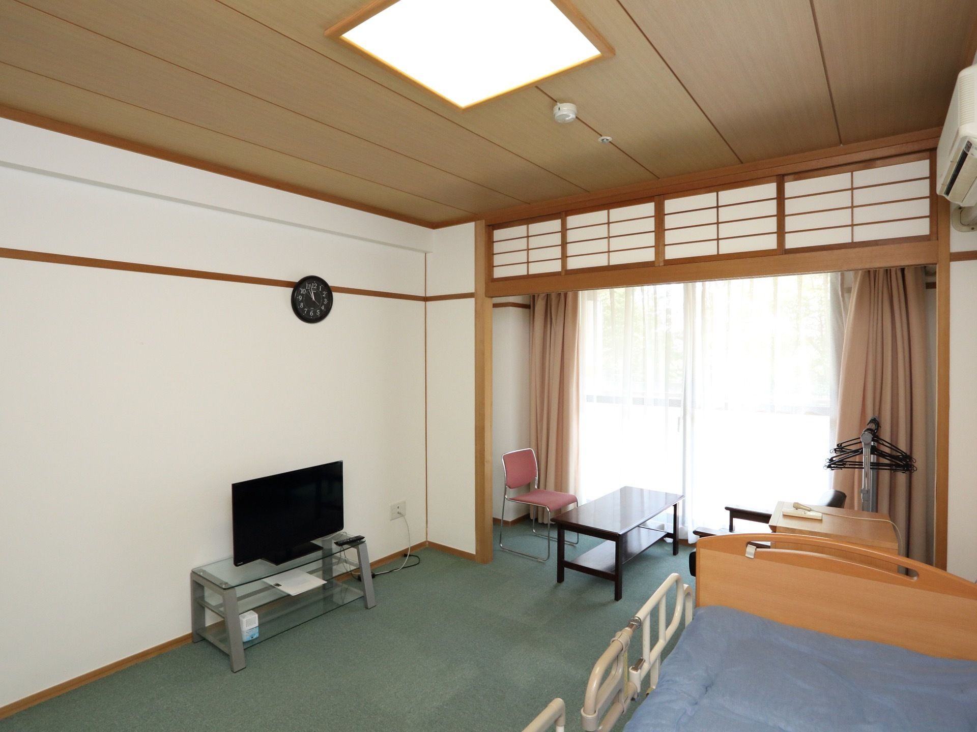 壁は白く天井は木目調になっており、欄間には障子がついている。窓際には椅子とテーブルがセットされている。