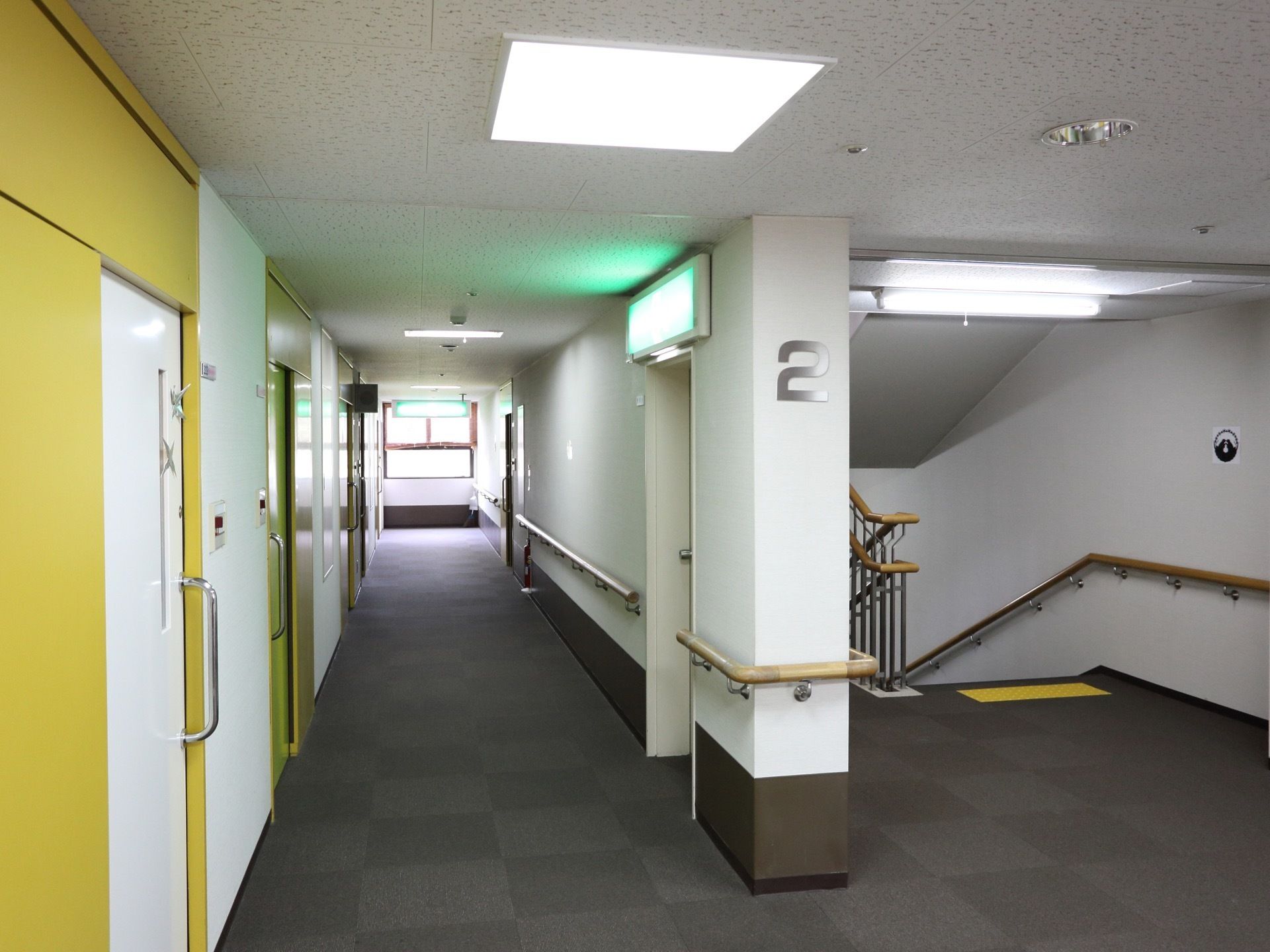 グレーのじゅうたんが敷かれており、壁には手すりが備えている。壁を挟んで右側には手すりがついた広い階段がある。