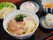 醬油ラーメンの周りに、ワカメ入りの三角おにぎり、レタスが添えられた２個のギョウザ、小皿に入った桃まんじゅうが並んでいる。
