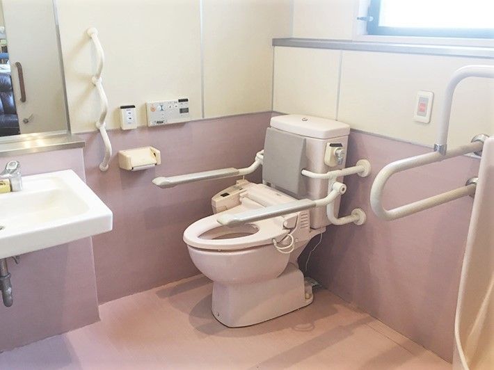 トイレの両側に手すりがついている施設内の介護仕様トイレの写真