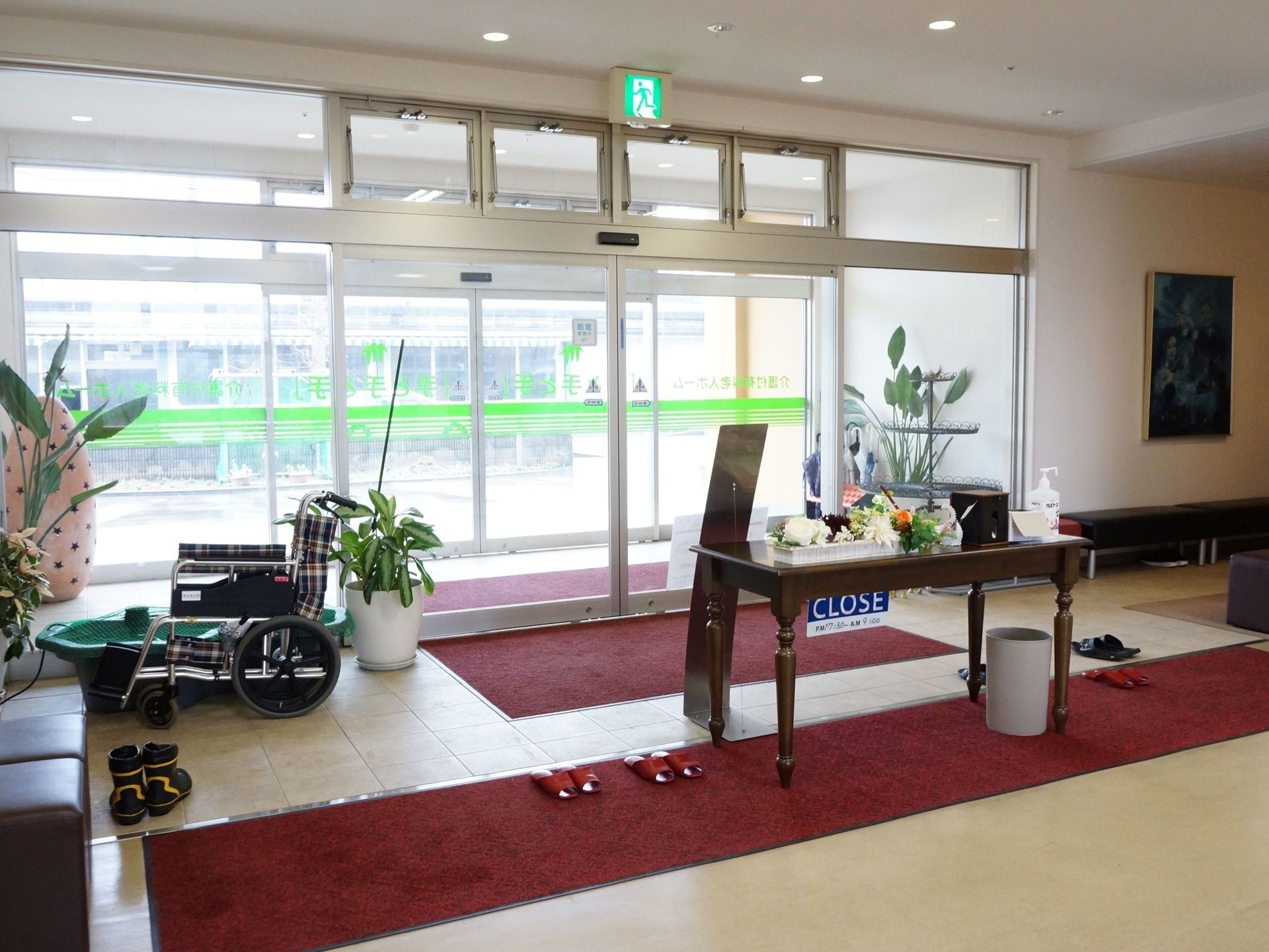 横幅のあるガラス張りの自動ドアなので、外の様子がよく分かる。真ん中にはテーブルが置いてあり、花が飾ってある。