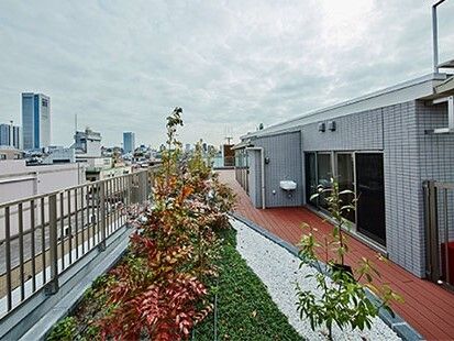 ウッドデッキが敷かれた屋上には庭園スペースがあり、周辺に街並みを見ることができる。