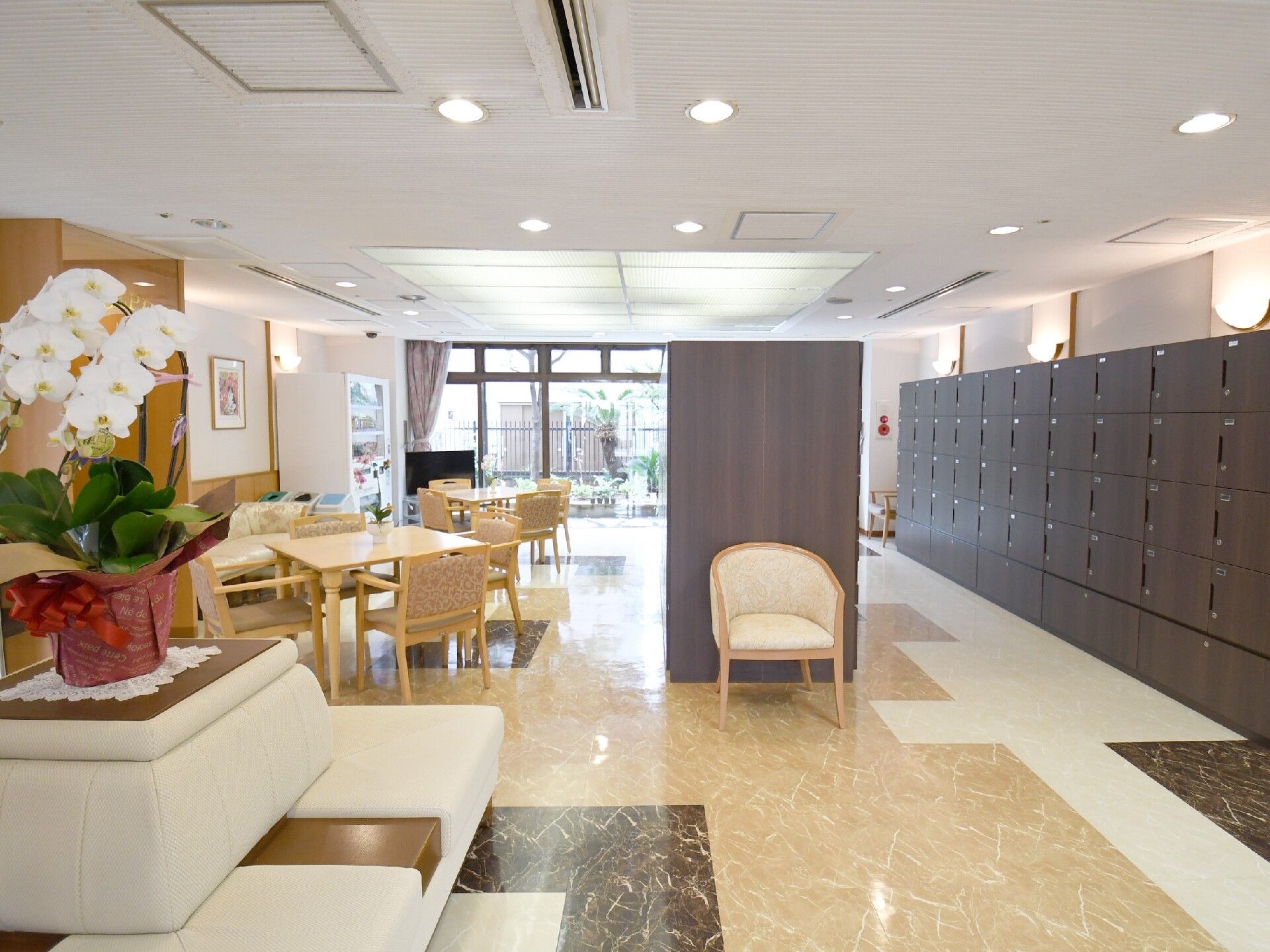 大理石調の床にベンチやテーブルを置き、壁際にはコンポを設置したロビー
