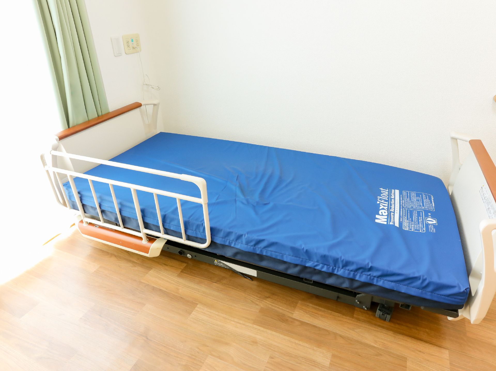 日差しが差し込み、介護ベッドや家具に日差しが当たっている居室