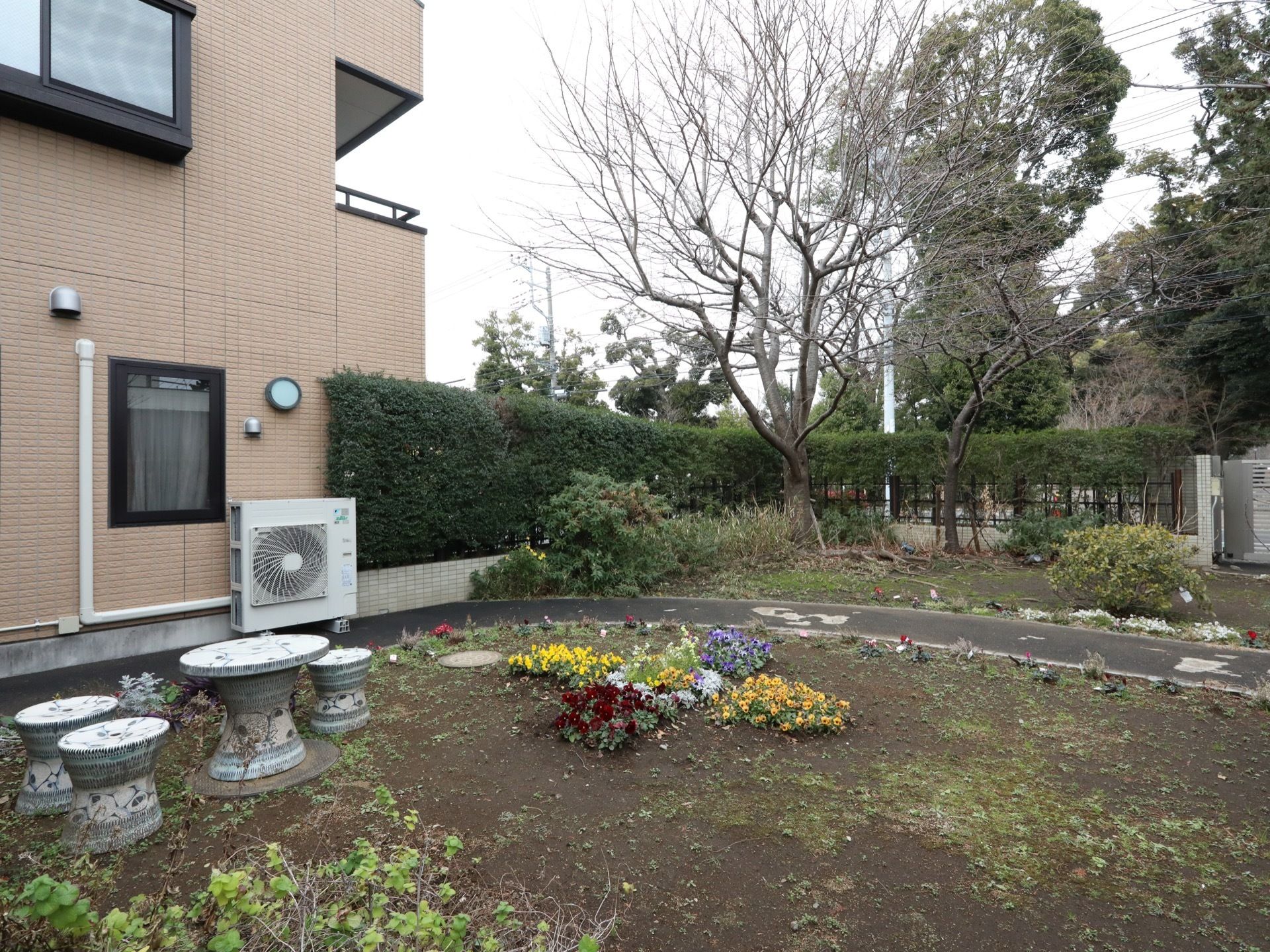 陶器材で施された丸テーブルと椅子が設置された中庭である。中央には、季節の色鮮やかな花が地植えされている。