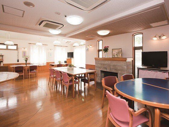 デザインの異なるテーブルセットが複数置かれた食堂は家庭的な雰囲気。大きなテレビも付いている。