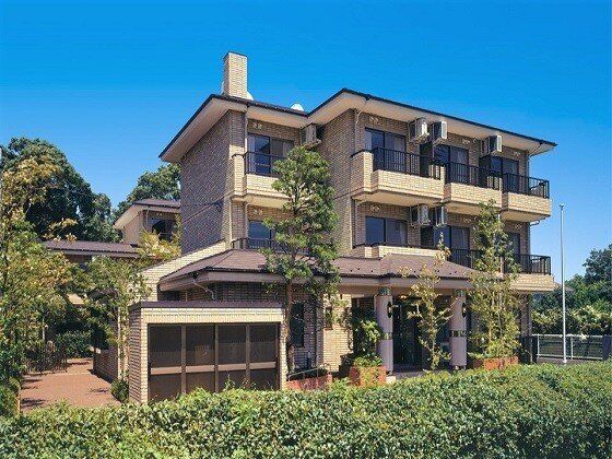 一般の住宅を大きくしたような家庭的な雰囲気の建物。周辺には緑が多く、各フロアにベランダが付いている。
