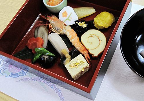 重箱に入った海老や栗きんとんなどのおせち料理