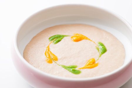 オレンジや緑のソースが円を描くようにトッピングされたミキサー食の一例