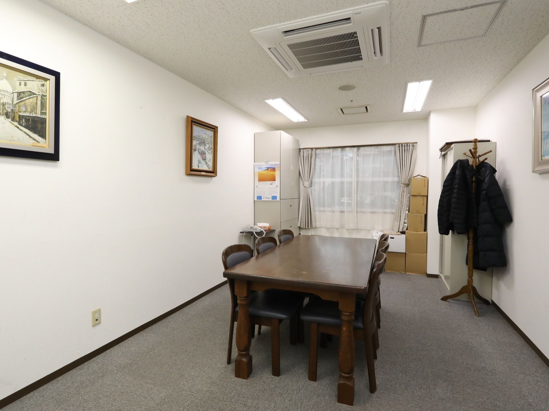 グレーのカーペットが敷かれた個室がある。天井には空調が付いており、部屋の真ん中にはテーブルセットが置かれている。