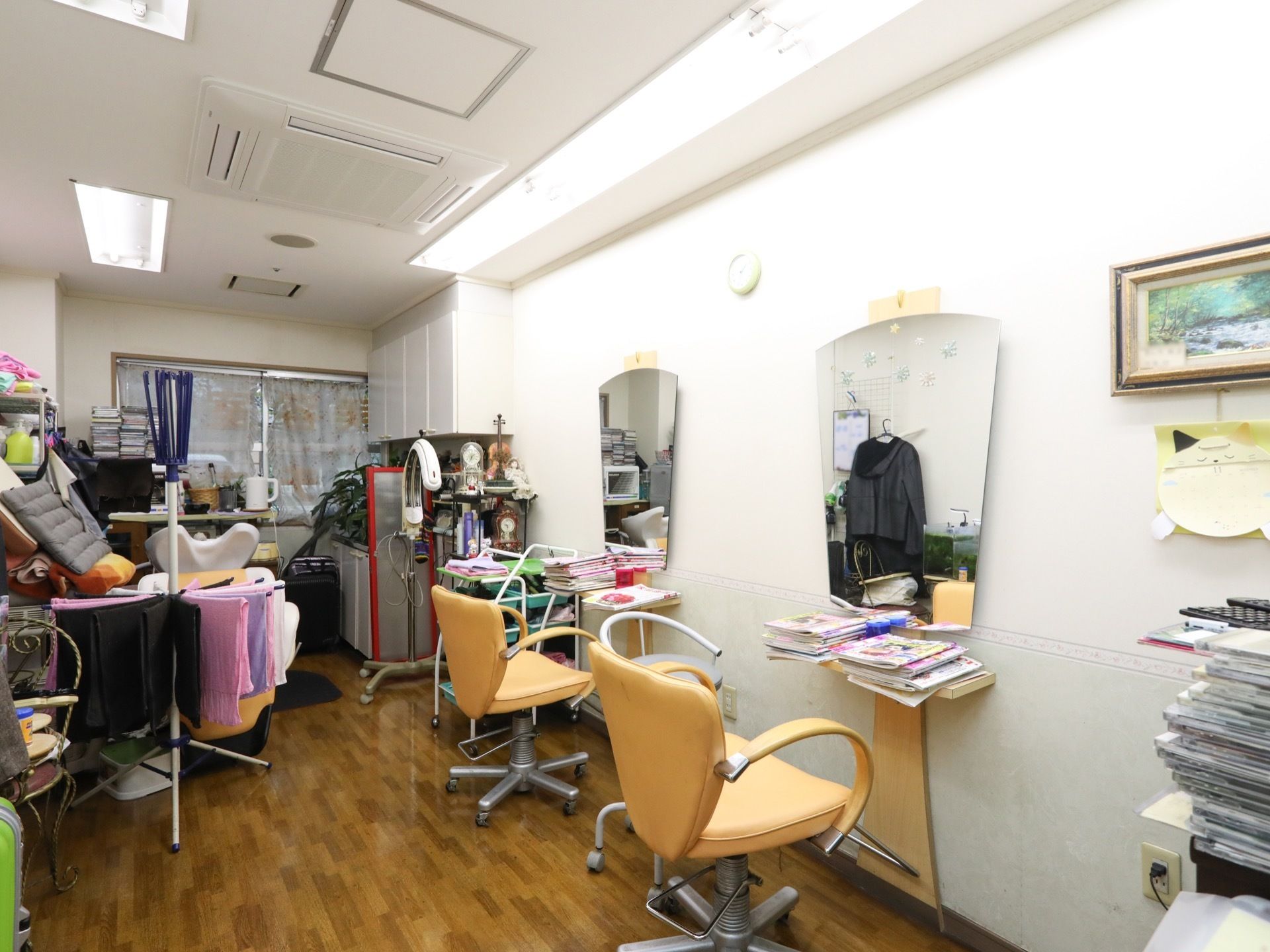 空調の付いたフローリングの部屋があり、鏡と椅子が2セット設置されている。近くにはフェイスタオルがたくさん干してある。
