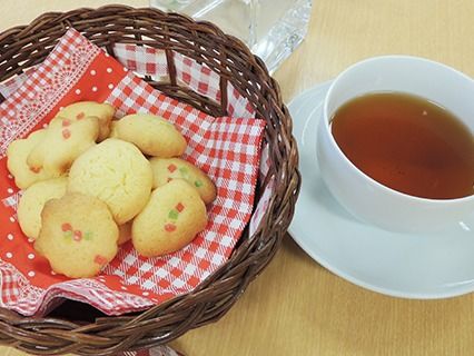 クッキーと紅茶を写した写真。かごに入れてあるかわいらしいクッキーとノーマルな紅茶