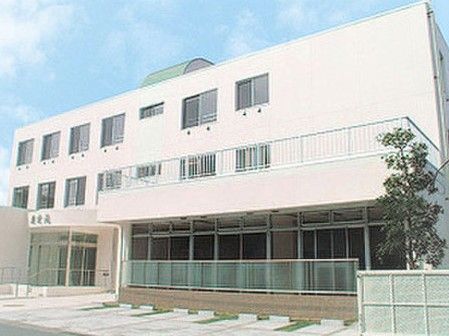 入口の半円型の屋根の横には、駐車スペースが４台分用意されている。施設は一階部分の屋根が張り出した３階建てである。