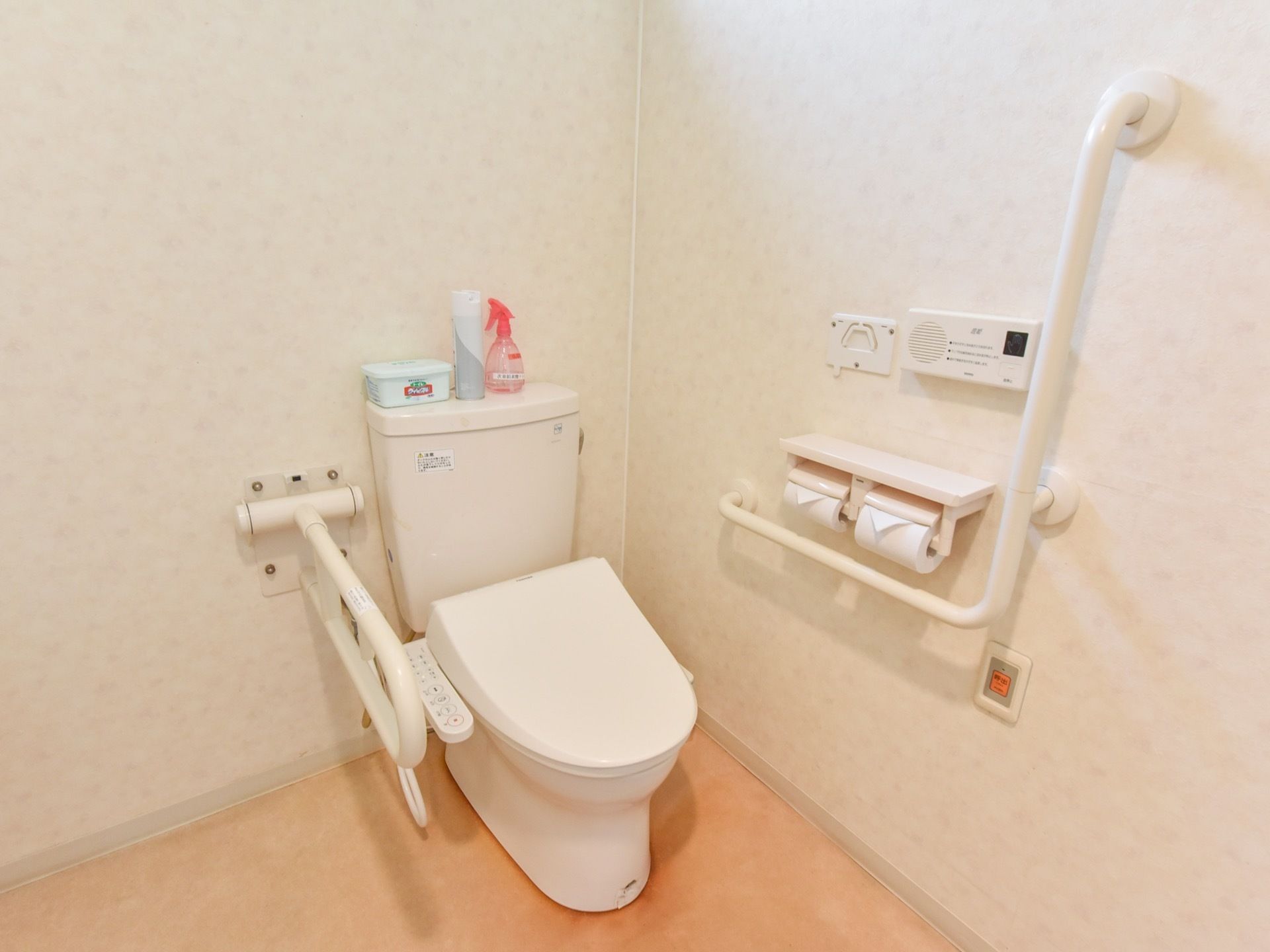 居室にトイレが備え付けてある。シンプルな造りに、手すりが取り付けられている。緊急ボタン取り付けられている。